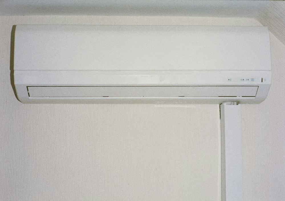 White ductless mini-split indoor unit mounted high on a pale wall